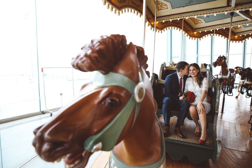a kiss at Jane's carousel in dumbo wedding