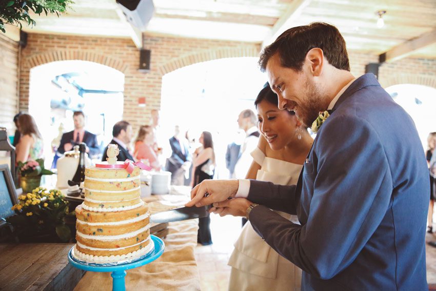 bride and groom cutting vegan cake