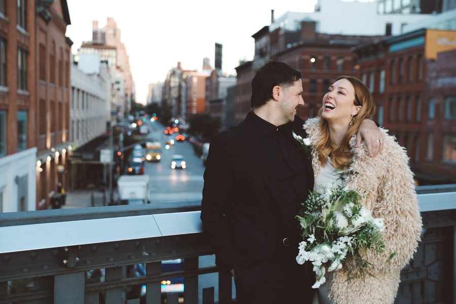 laughing while standing on the bridge of the Highline Park in NYC