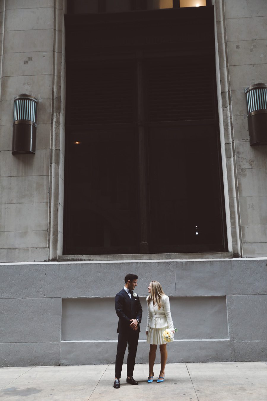 couple standing next to big NYC wall