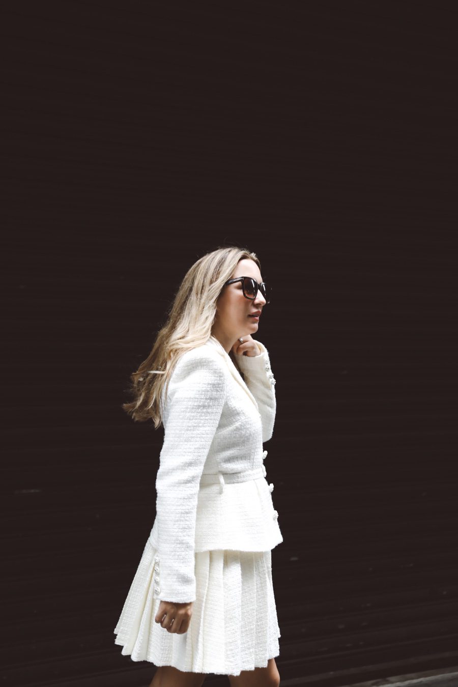 bride fixing her hair with a black background