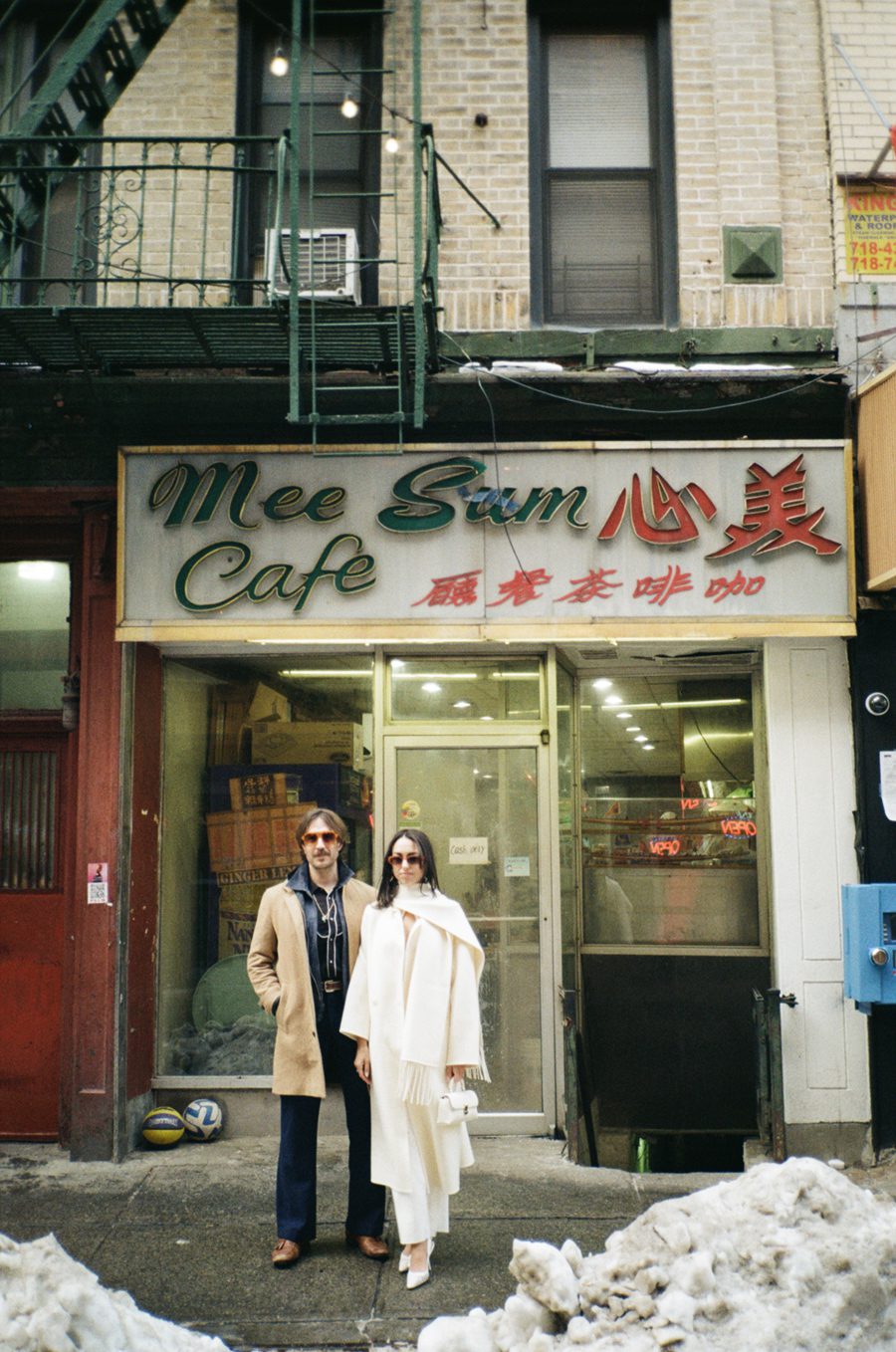 A couple in front of Mee Sun Cafe in Chinatown NYC