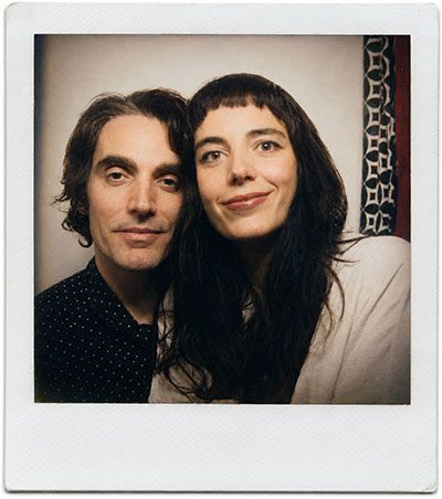 A man and a woman pose closely for a casual selfie, smiling at the camera inside a Polaroid-style photo frame